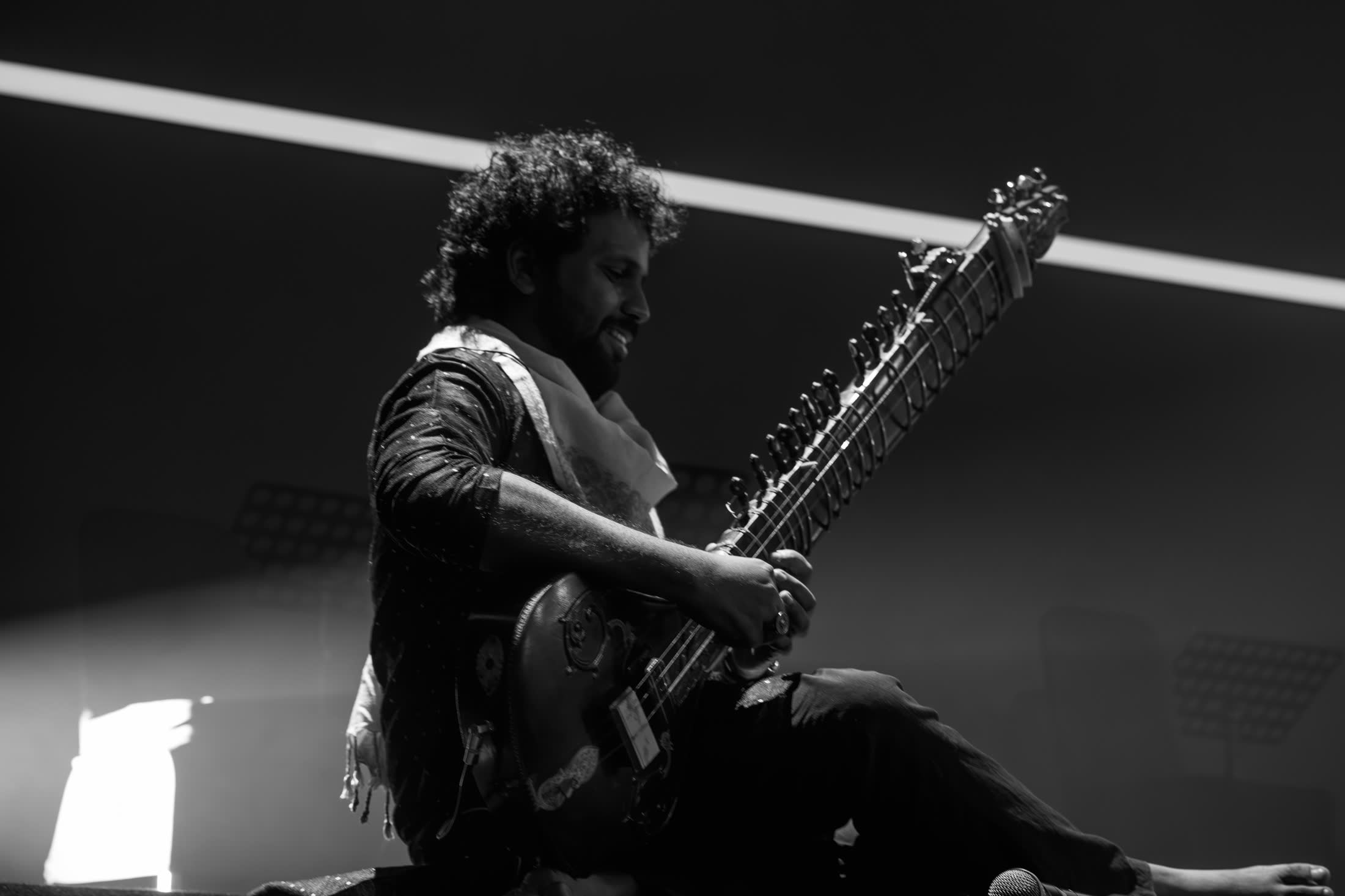 Sitarist in a shaft of white light